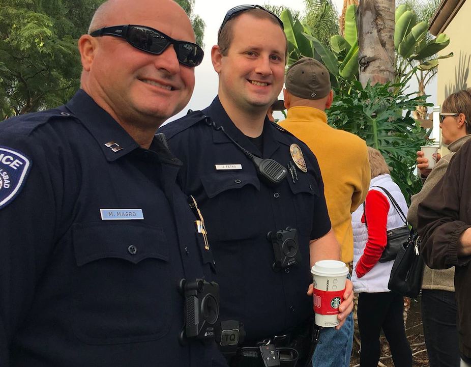 Two police officers drinking coffee while wearing body-worn cameras