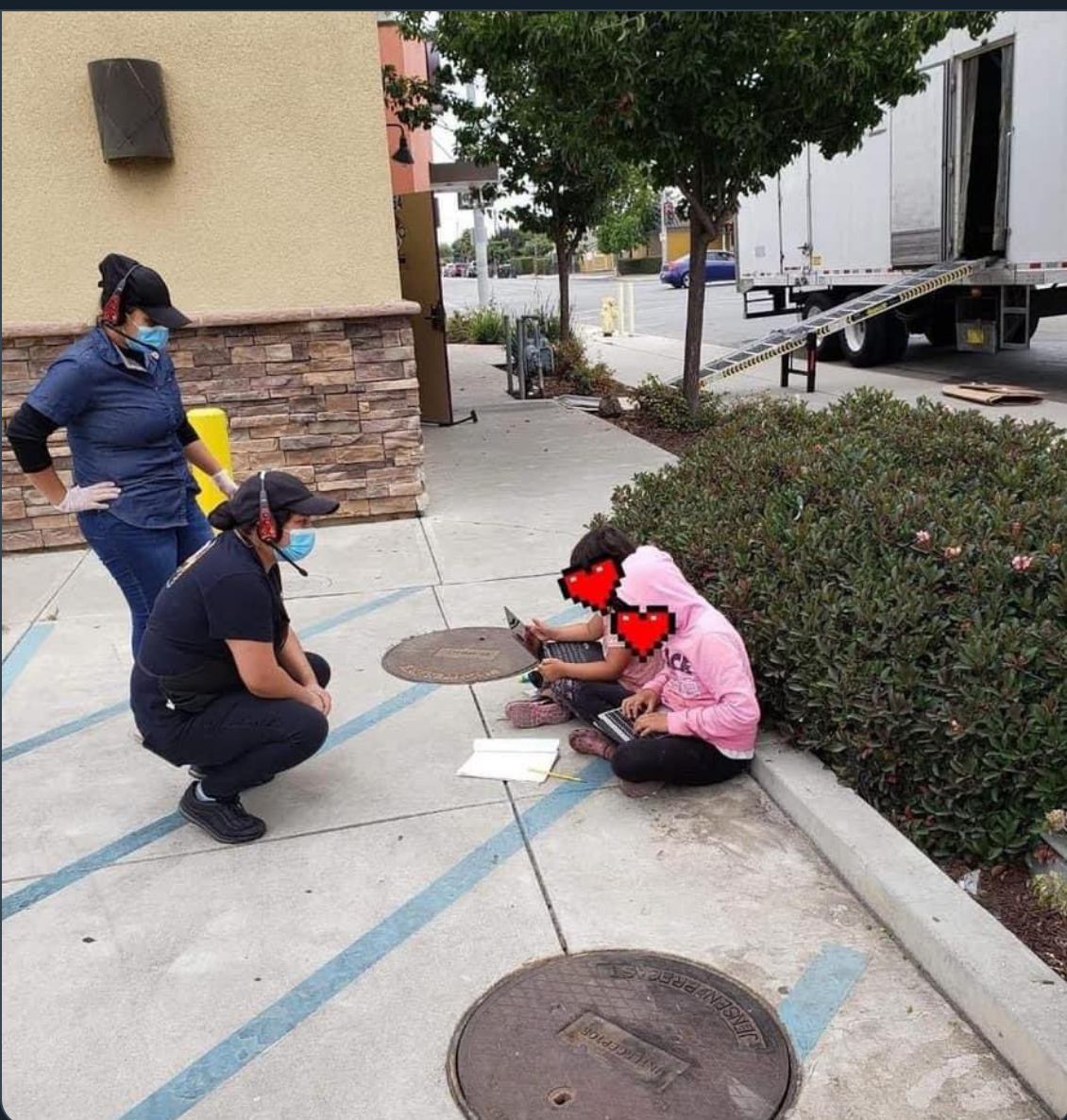 Two students sit outside a Taco Bell fast food restaurant to gain access to the restaurant's Internet.