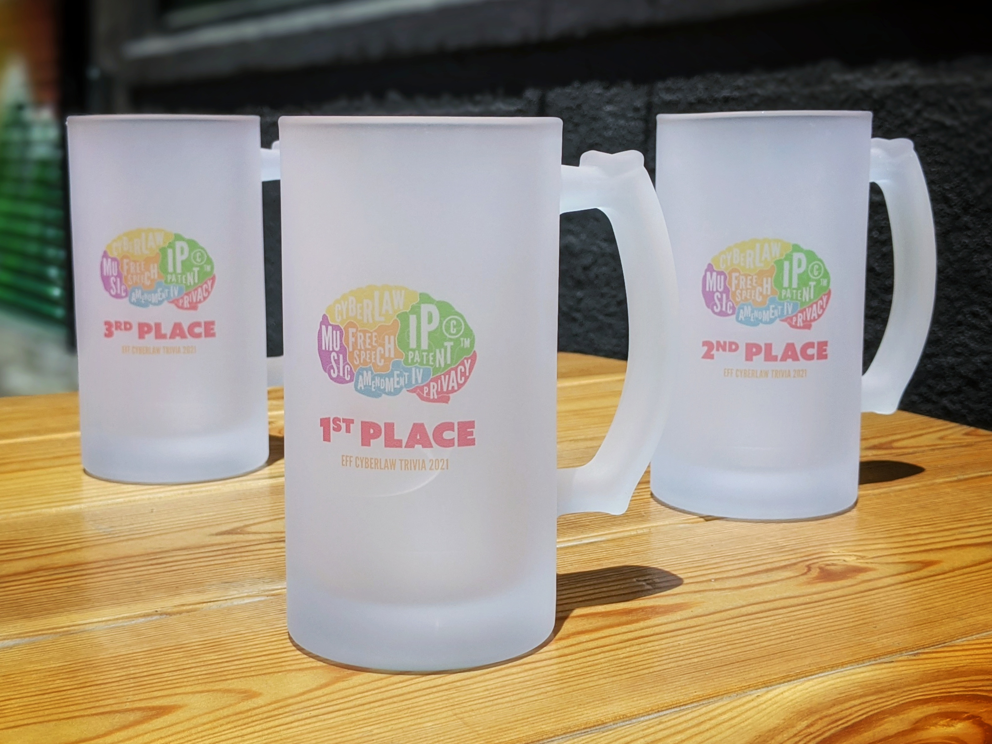 Photo of the coveted Cyberlaw Quiz Cups, which are actually large glass steins, with 1st place in the center, 2nd place to the right, and 3rd place to the left.