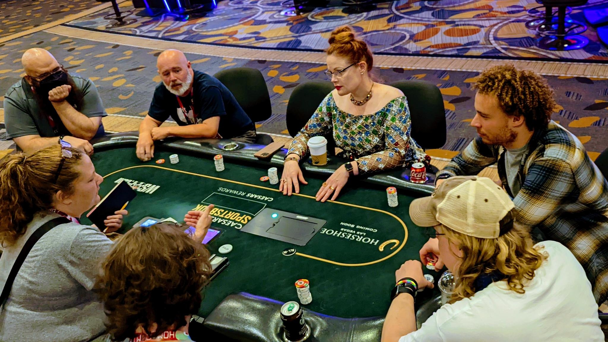 People listening to someone around a poker table.