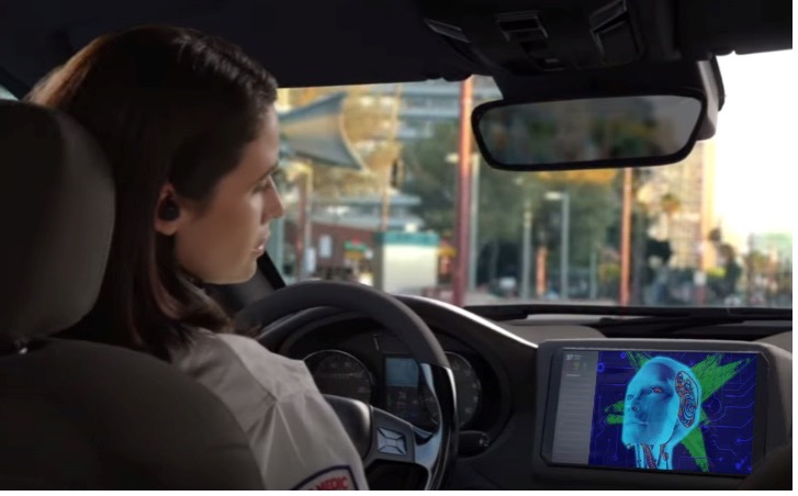 A female driver talking to a digital face on a screen