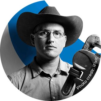 Black and white photo of Kyle Wiens holding a large wrench with a blue stripe on a white background